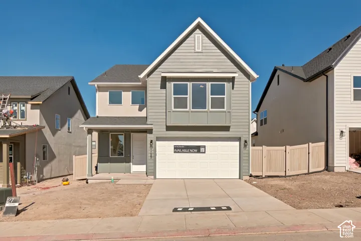 Two-story residence featuring horizontal siding, a gabled roofline, a front-facing bay window, and an attached two-car garage with a concrete driveway