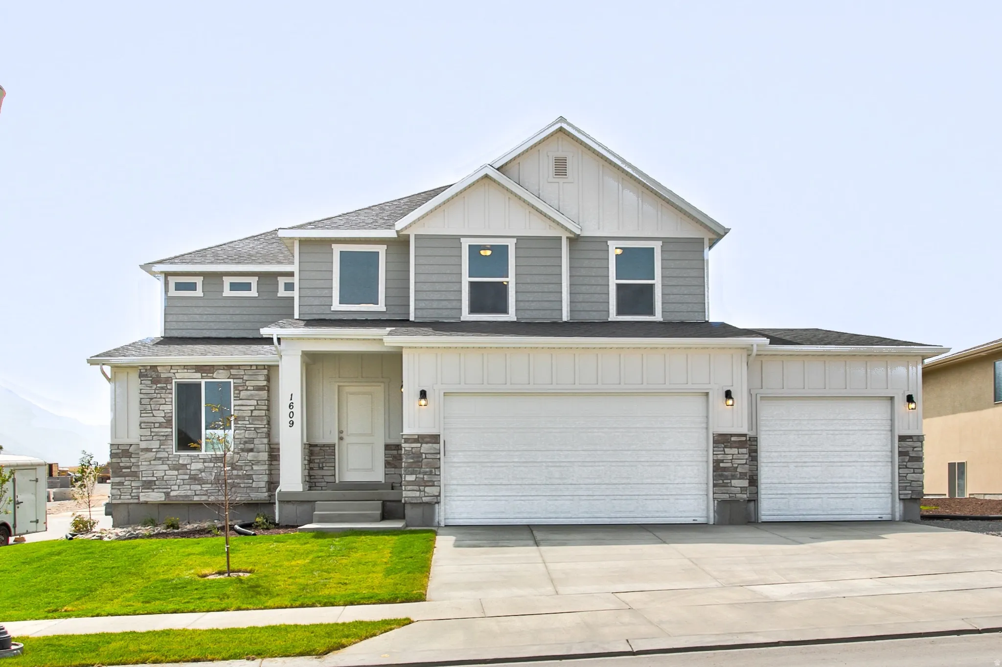 Two-story exterior with a mixed material facade, featuring stone and siding
