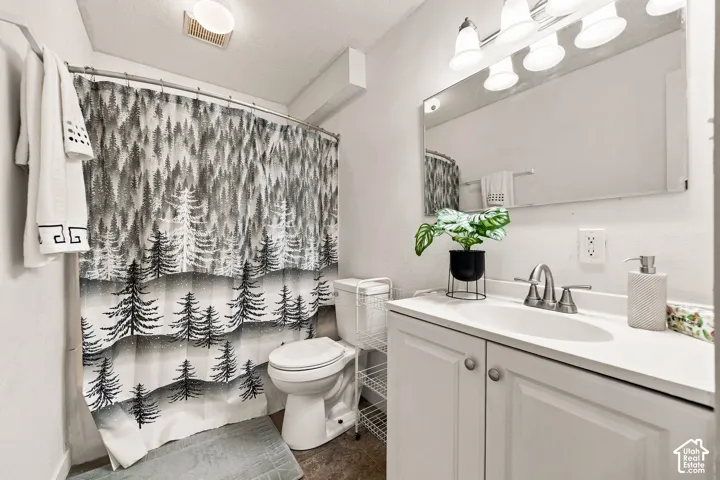 White vanity with integrated sink, brushed nickel faucet, wall-mounted mirror, and overhead lighting