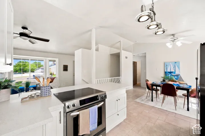 White cabinetry with stainless steel hardware, built-in stainless steel oven, light-toned countertop, and light-toned floor tile