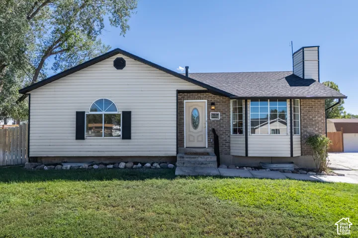 Single-story residence featuring a combination of brick and siding exterior, a bay window, and an arched window with shutters. Beveled Glass front door.