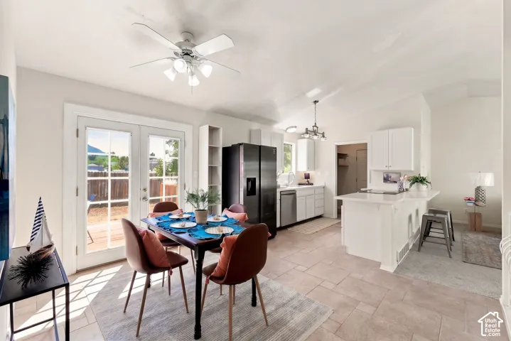 Open concept living space featuring neutral wall tones, tile flooring, and white cabinetry