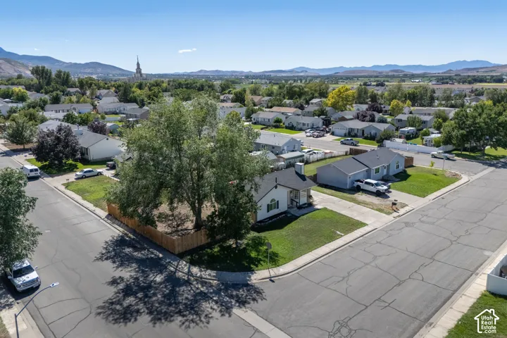 Single-story corner lot, with white siding and dark roofing