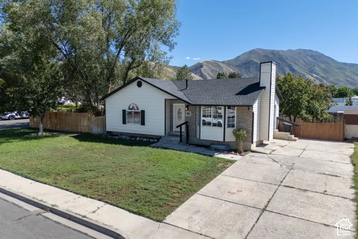 Single-story residence featuring white siding and brick accents. RV parking.