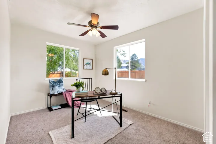 Recessed ceiling light with fan, two large windows, and neutral carpeting
