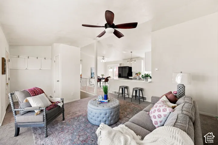 Vaulted ceiling with a ceiling fan, recessed lighting, and a breakfast bar with built-in cabinetry