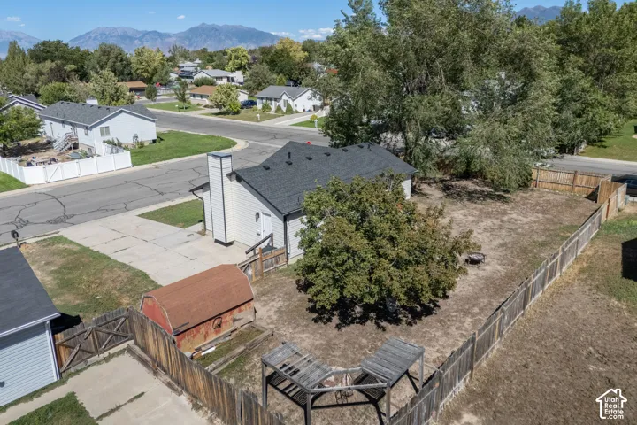 Fenced backyard with mature trees and a detached shed