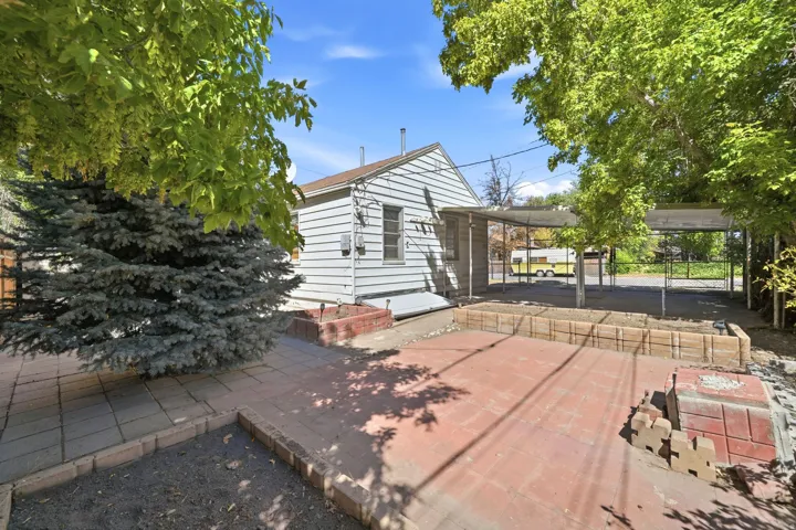 Spacious brick patio with mature shade trees and lush landscaping