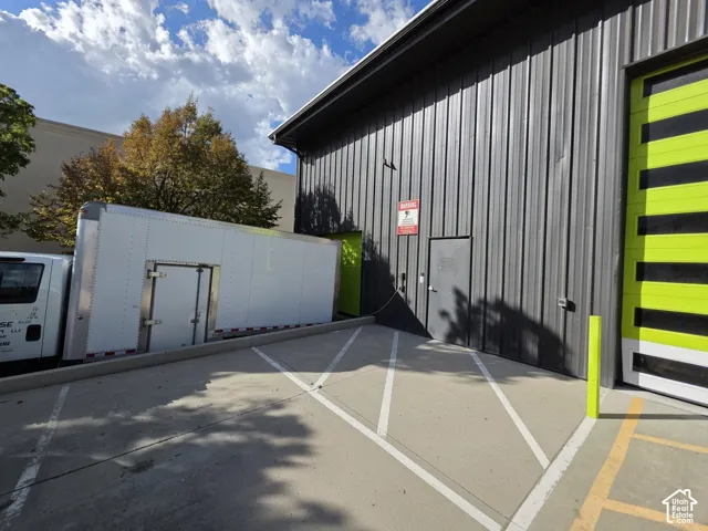 Corrugated metal siding exterior with a large roll-up door and a standard entry door