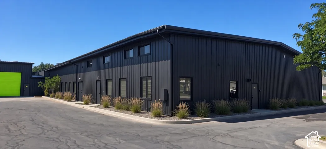 Two-story commercial building featuring dark panel siding and multiple entry doors