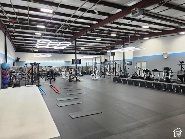 Spacious open-concept interior featuring high ceilings, exposed structural beams, and recessed lighting
