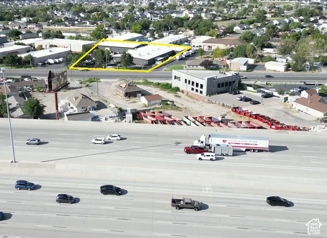 Commercial property with multiple structures, expansive paved lot, and direct highway access