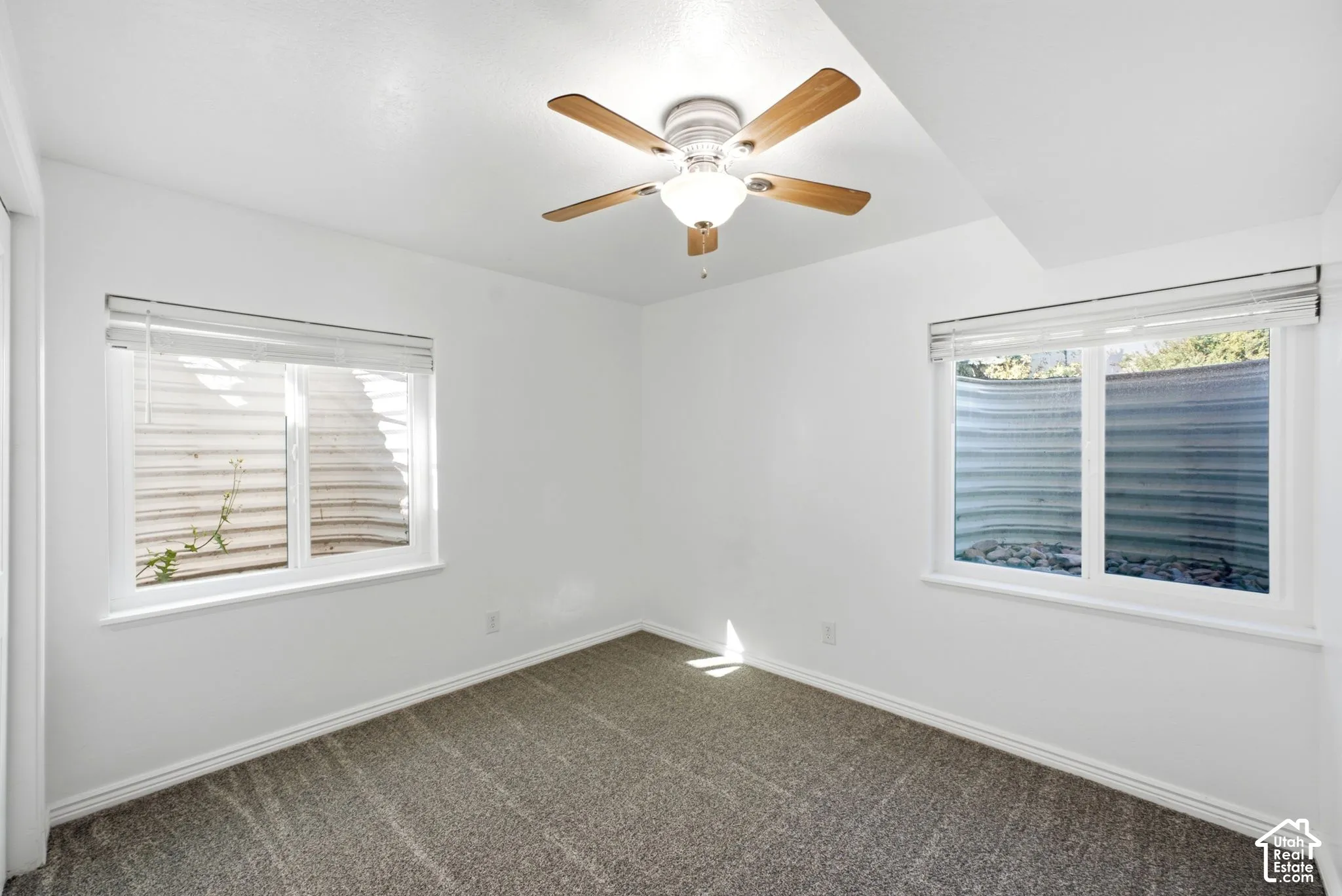 Recessed lighting, ceiling fan with light fixture, two windows, and gray carpet flooring
