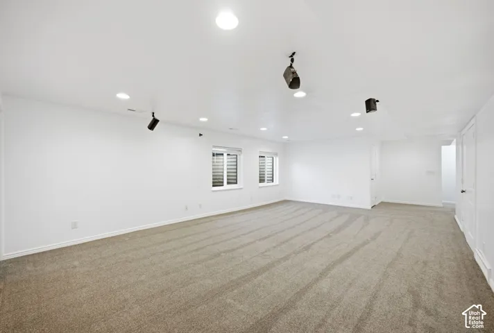 Expansive carpeted room featuring recessed lighting and built-in ceiling speakers
