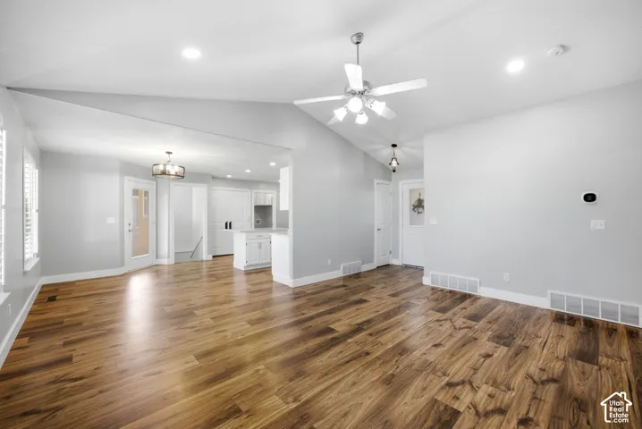 Vaulted ceilings with a ceiling fan, wood-finish flooring, white plantation shutters, built-in white cabinetry, and recessed lighting