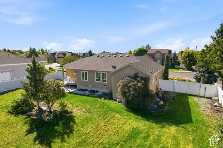Expansive rear lawn with mature trees, a private deck, and a full perimeter fence