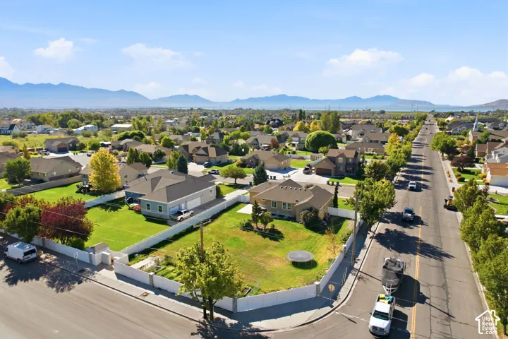 Residential neighborhood with established homes, mature trees, and visible mountains