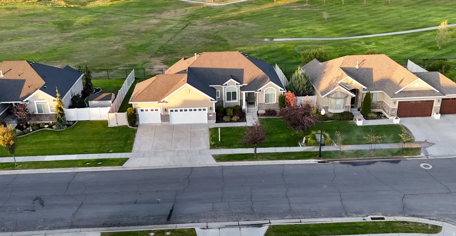 Residential property featuring a concrete driveway, attached garage, and a manicured lawn