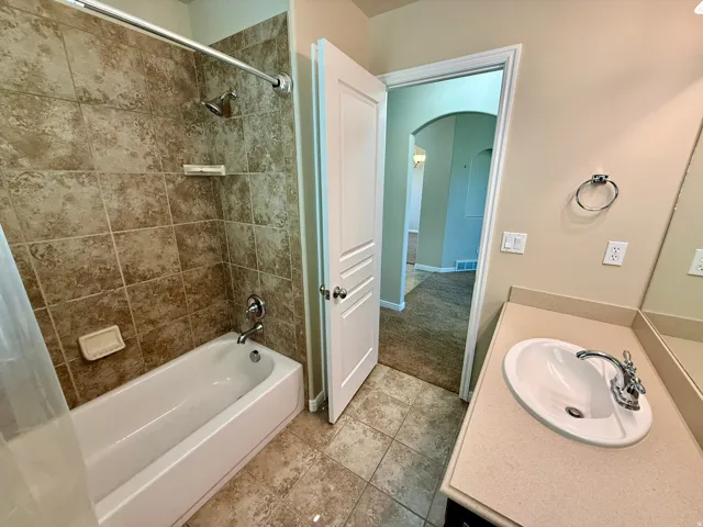 Bathroom 2- Tub/shower combination featuring tile surround