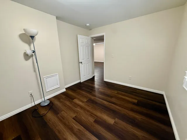 Bedroom 5, Wood-finish LVP flooring with white trim, light-toned walls