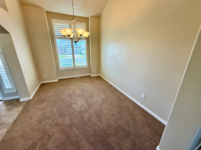 Formal sitting room or formal dinning room with vaulted ceilings that accentuate the spacious room with extra tall windows.