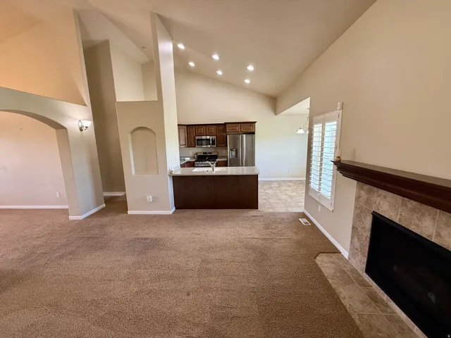 Great room with vaulted ceilings, recessed lighting, and an arched entryway