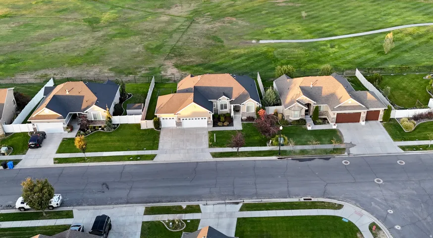 Manicured green spaces, expansive driveways, and a well-maintained street