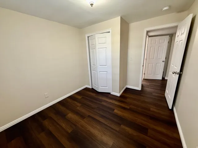 Bedroom 6 Wood-finish flooring, neutral wall tones, bi-fold closet doors, and overhead lighting