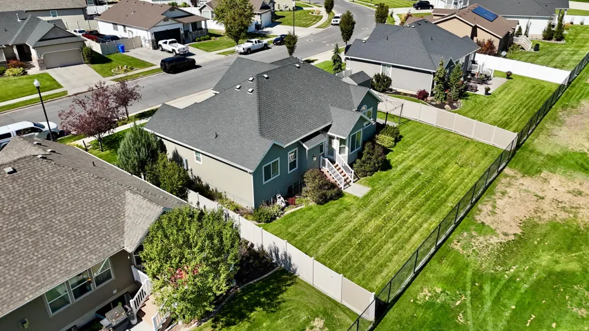Well-maintained lawn with a privacy fence, complemented by mature trees and shrubs