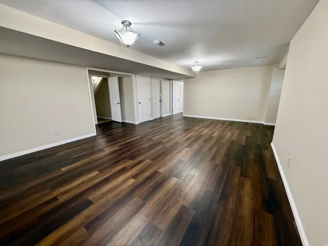 Expansive room featuring wood-finish flooring, light-toned walls, and recessed lighting, LVP flooring