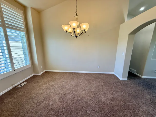 Formal sitting room or formal dinning room with vaulted ceilings that accentuate the spacious room with extra tall windows.