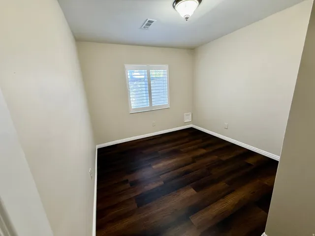 Bedroom 6, Recessed window with plantation shutters, wood-finish flooring, and a semi-flush mount ceiling fixture
