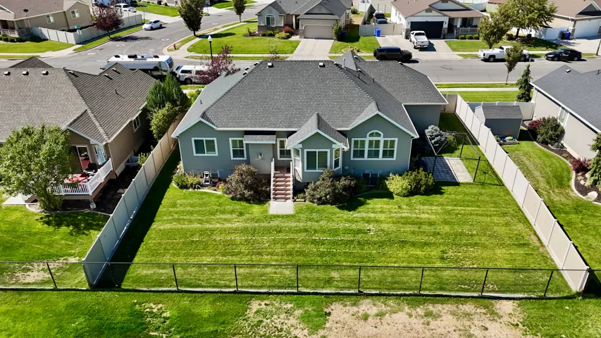 Expansive backyard with a manicured lawn, a privacy fence, and a chain-link fence along the back for unobstructed views.