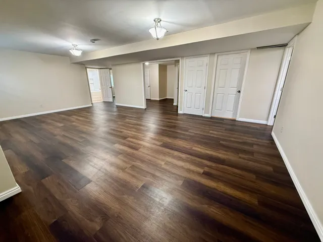 Spacious room featuring wood-finish flooring, neutral-toned walls, and LVP flooring