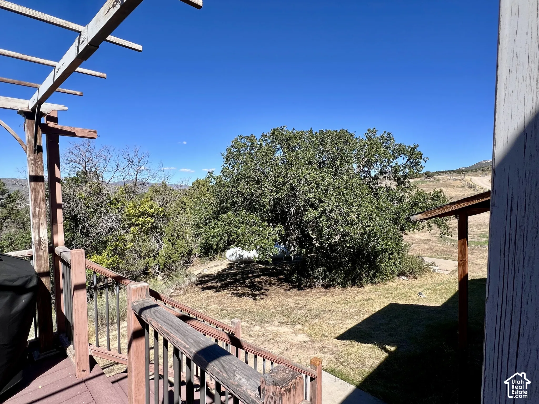 Spacious outdoor deck with wood railing, and natural landscape