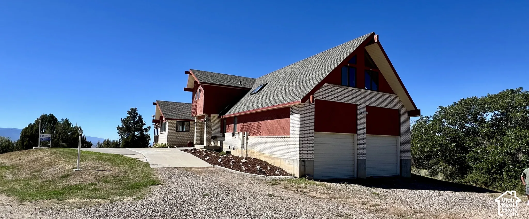 Two-car garage with white doors, red siding, and white brick accents