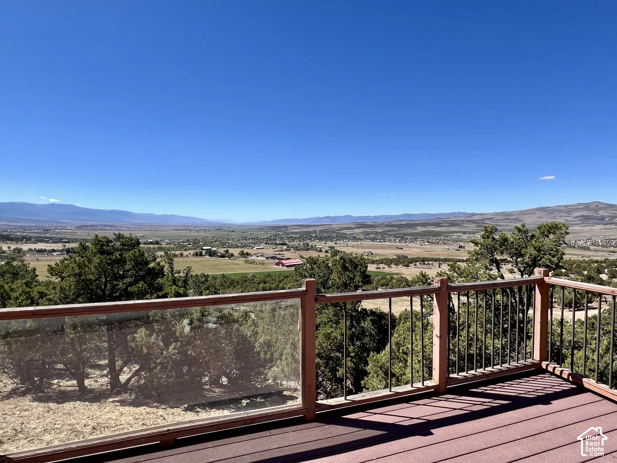 Expansive outdoor deck with composite decking and glass panel railing