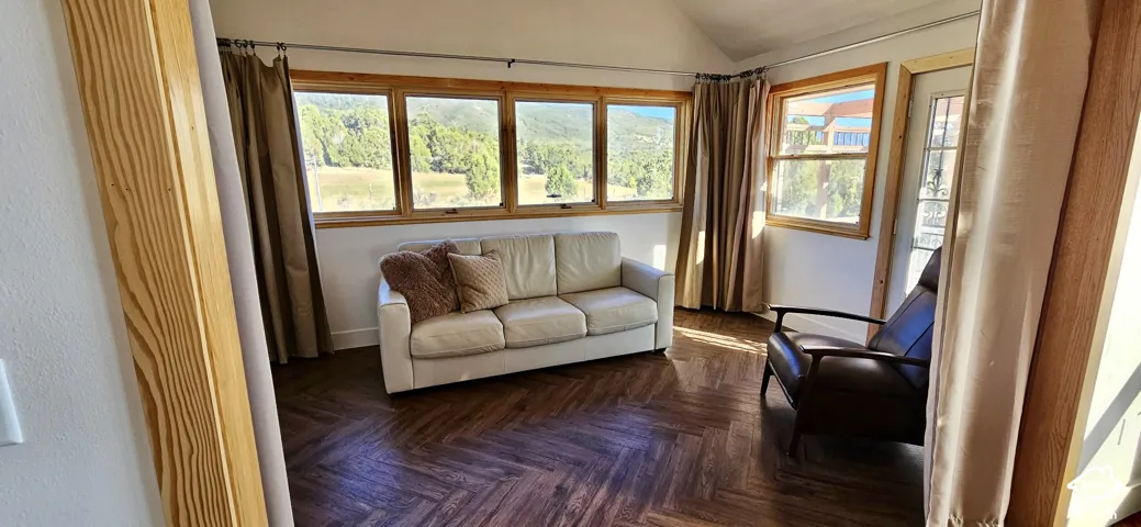 Wood-finish herringbone flooring, wood-framed windows, and sloped ceilings
