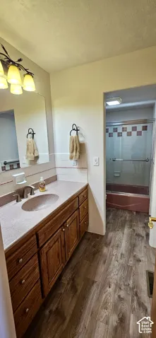 Long vanity with wood cabinetry, an integrated sink, and a framed mirror