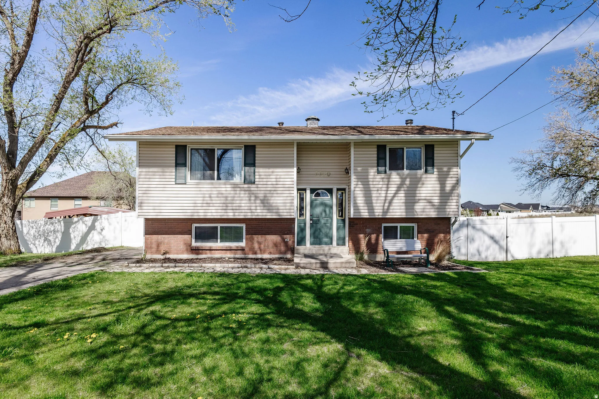 Two-story exterior with light-colored siding and brick-finish lower level