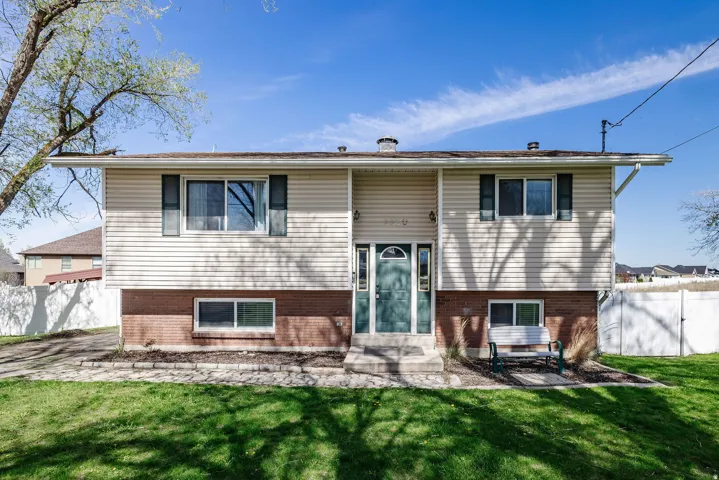 Split-level residence featuring a brick and siding exterior, front entry with a transom window, and a gabled roofline