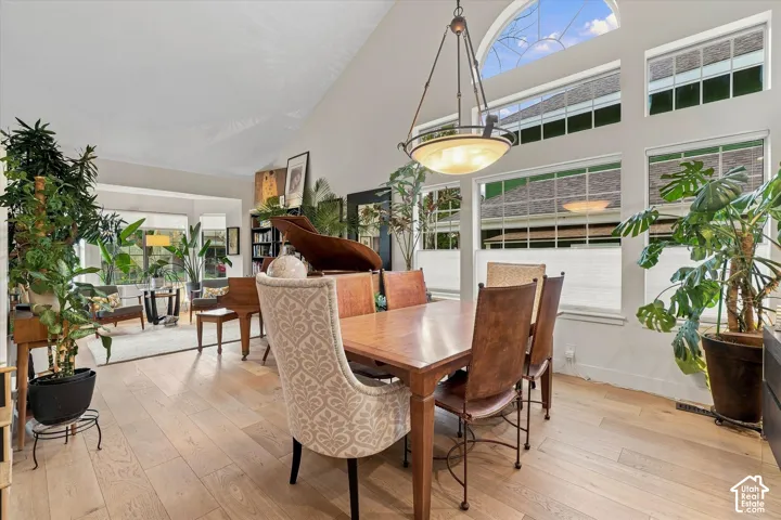 Dining Area with vaulted ceiling, a decorative chandelier & expansive window array