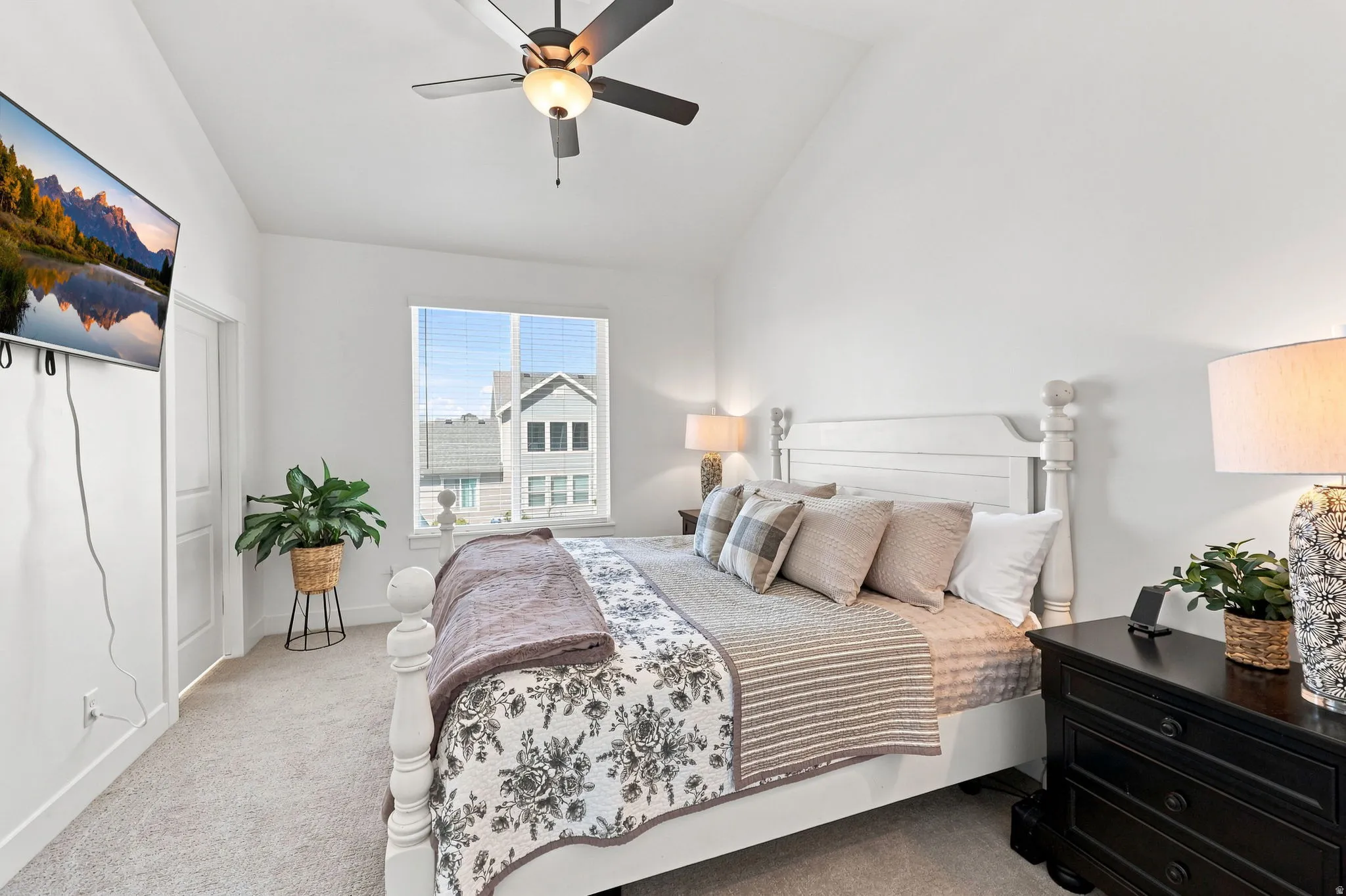 Vaulted ceilings with a ceiling fan, carpet flooring, window with blinds, and a paneled interior door
