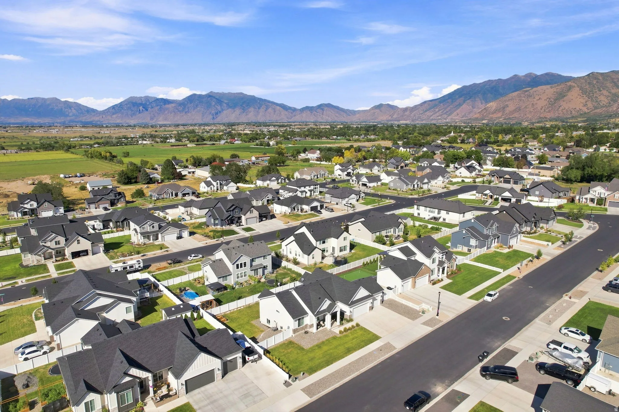 Residential neighborhood with diverse home exteriors, structured streets, and distant mountain scenery