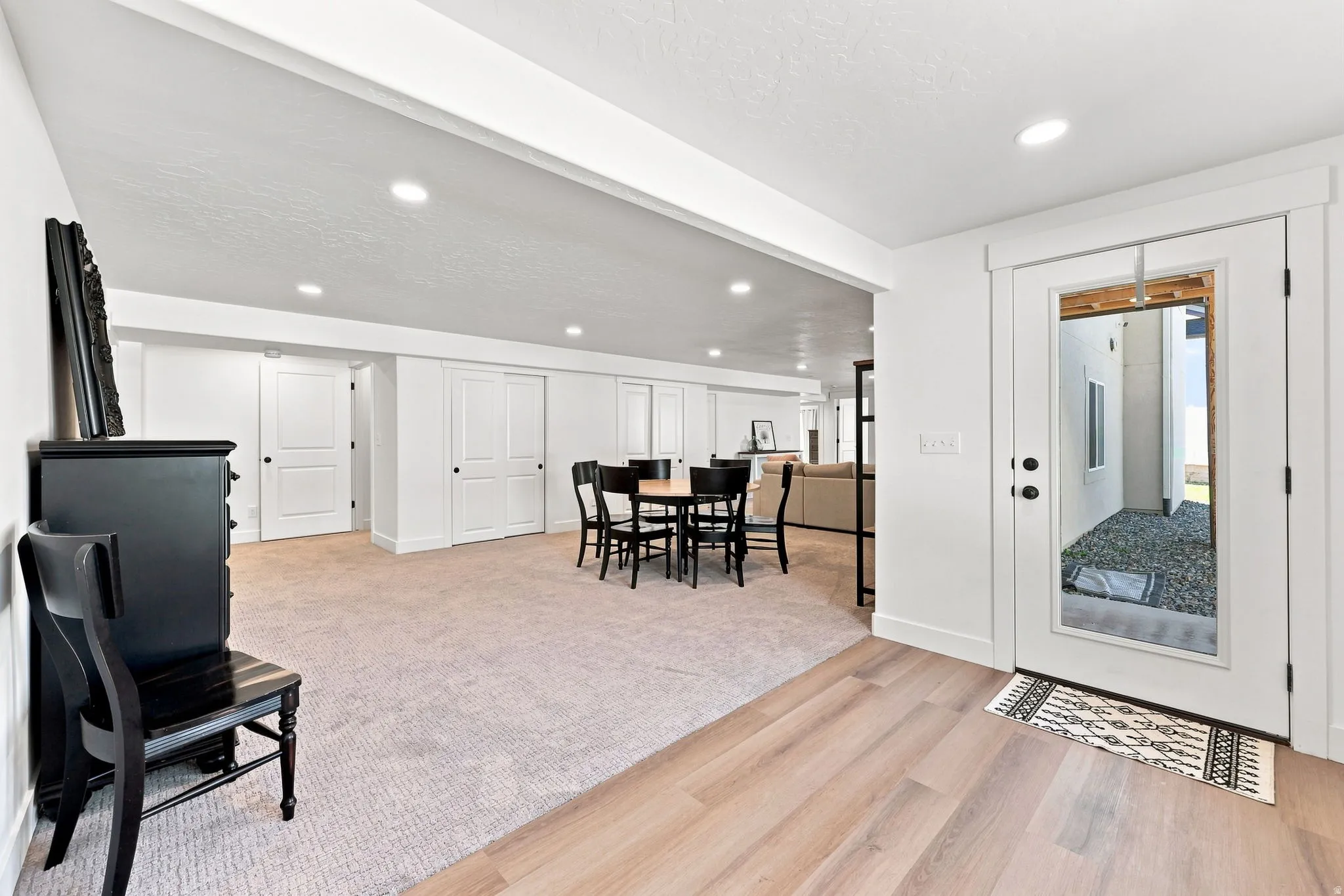 Recessed lighting, wood-finish flooring, full-light exterior door, and light-toned carpeting