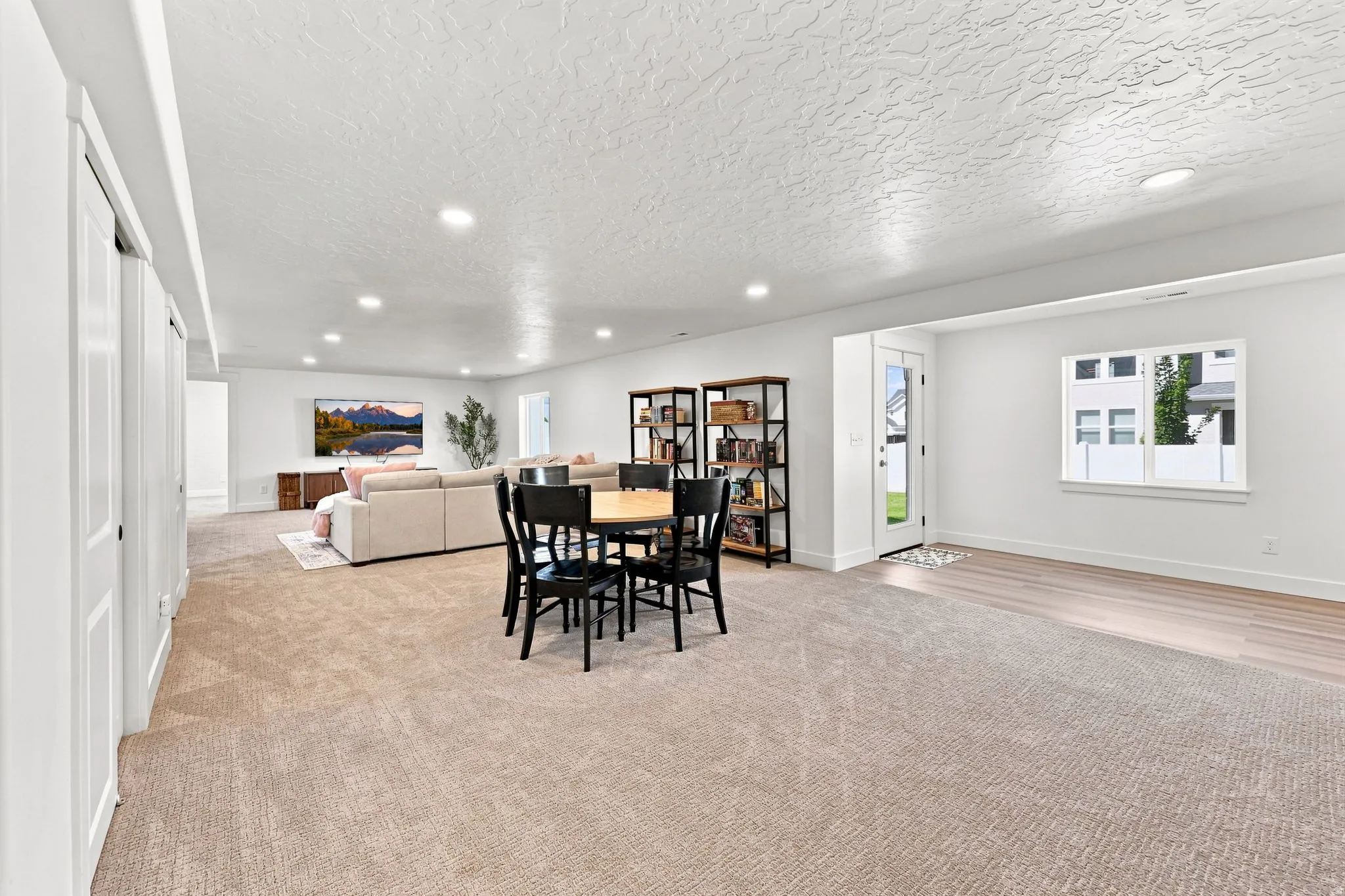 Recessed lighting, wood-finish flooring, white trim, and a glass-paneled door