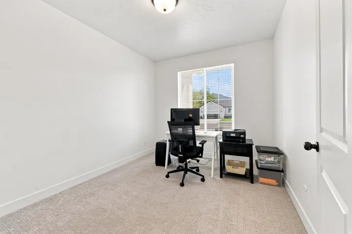 White walls, neutral carpet, and a window with horizontal blinds
