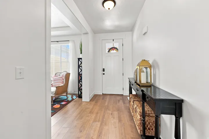 Entryway featuring wood-finish flooring, a white paneled entry door with a decorative glass insert, and recessed ceiling lighting