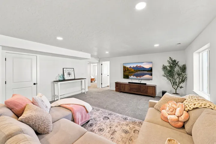 Recessed lighting, white walls, gray carpet flooring, white trim, white window frame