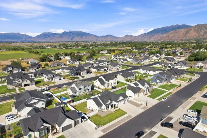 Residential neighborhood with diverse home exteriors, structured streets, and distant mountain scenery